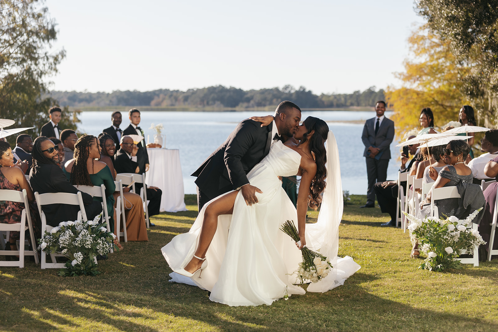 couple doing a dip and kiss on their wedding day, leaving their ceremony